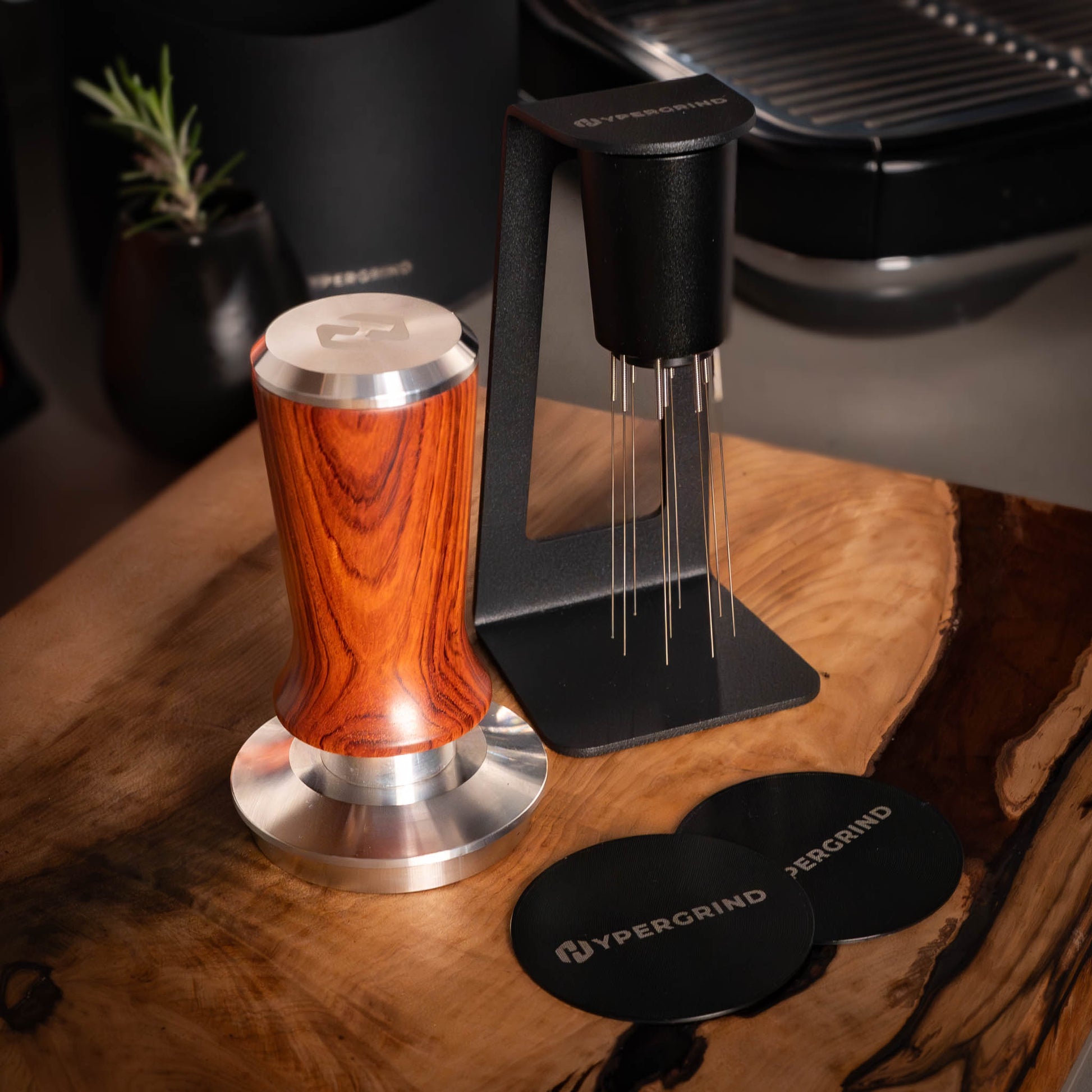 Wooden coffee tamp, wdt tool and black puck screens on a wooden surface with Hypergrind branding.