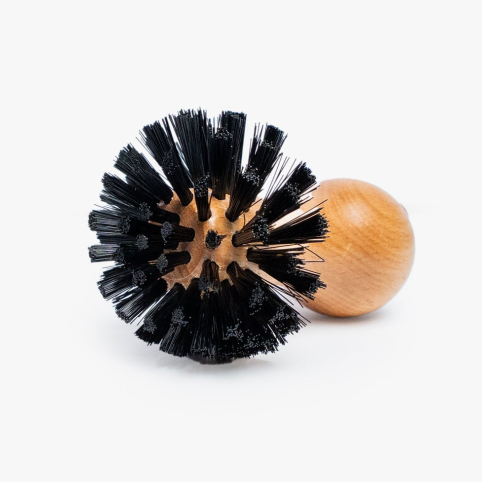 Black bristle brush and wooden handle on a white background