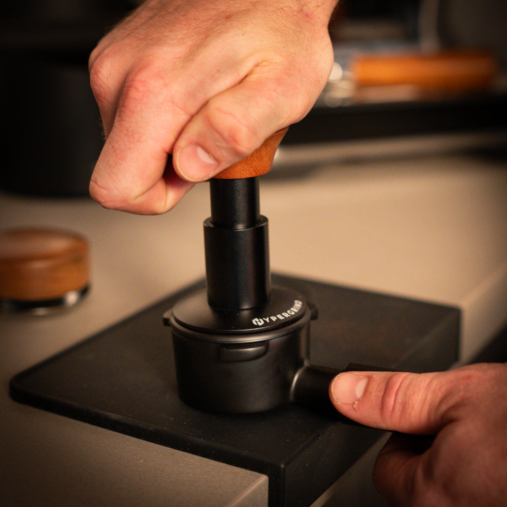 Self Levelling Force Tamper (Black/Rosewood) being used on a black portafilter