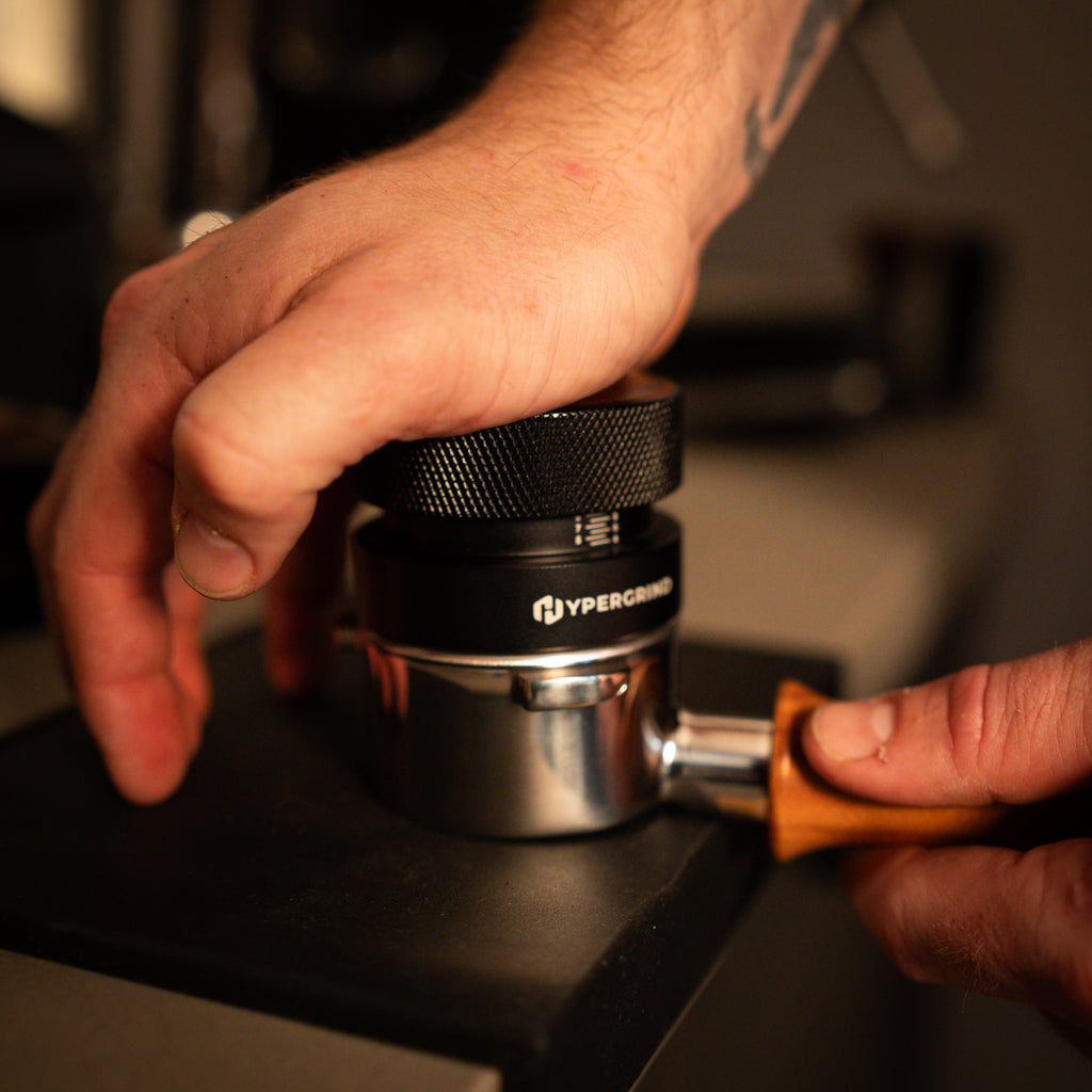 Self Levelling Palm Coffee Tamper (Black/Walnut) being used in portafilter 